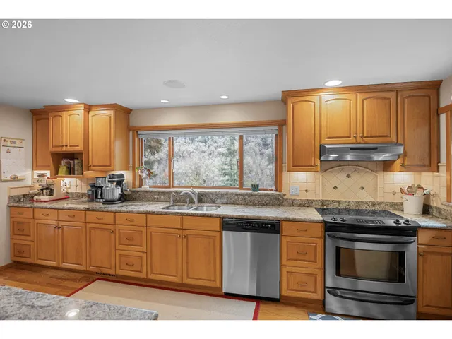 a kitchen with stainless steel appliances granite countertop a stove a sink and a microwave