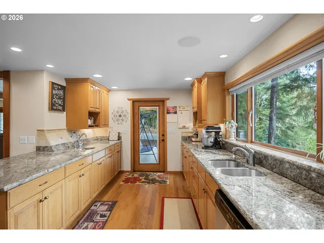 a large kitchen with granite countertop a large window and a counter space