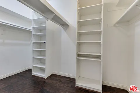 a view of walk in closet with empty racks