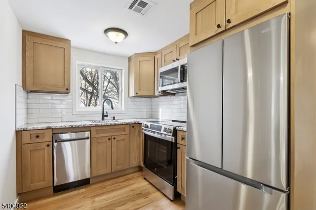 a kitchen with stainless steel appliances granite countertop a refrigerator and a sink