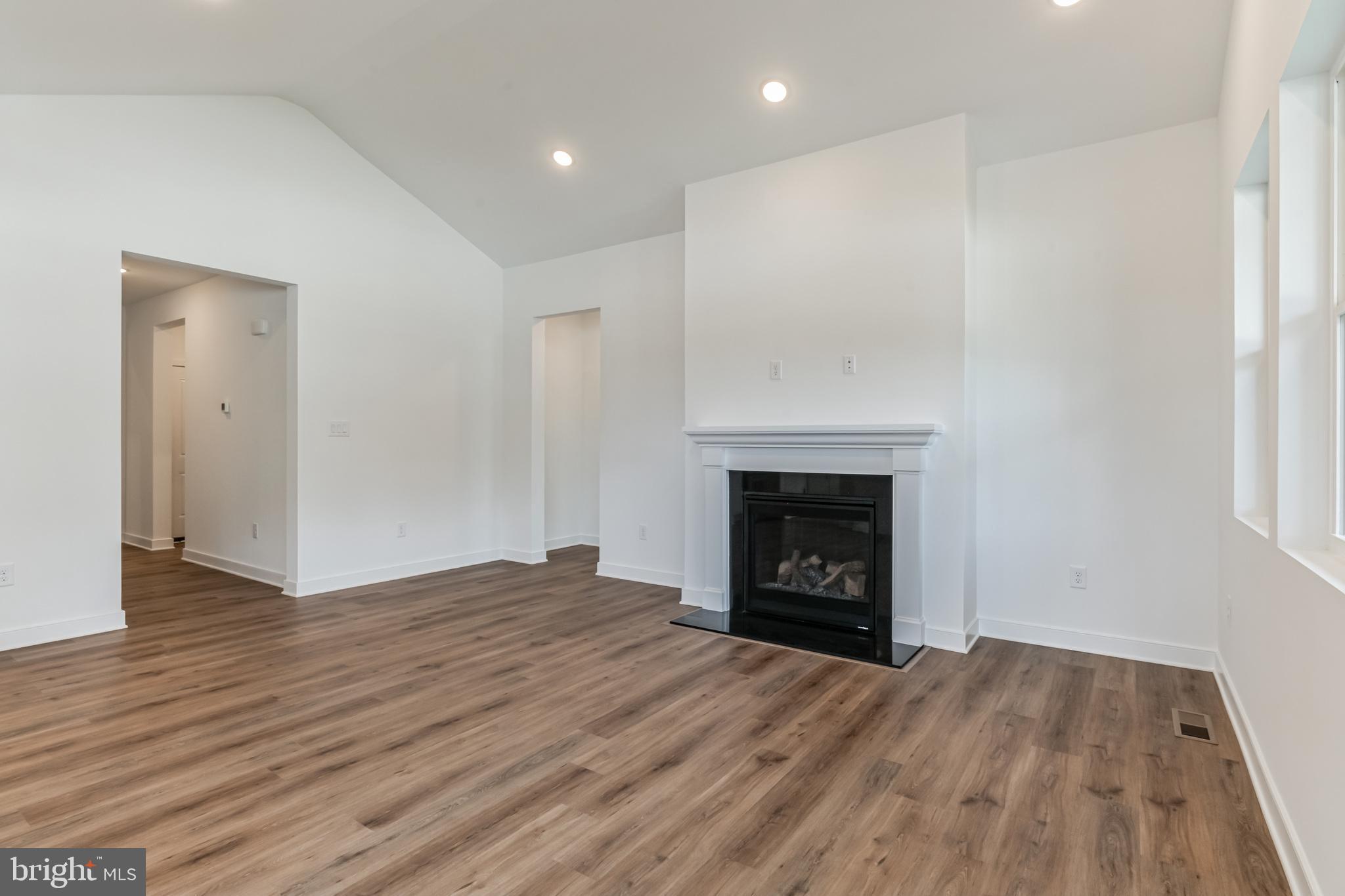 36449 Maple Ridge Lane Georgetown, DE 19947 - Photo 15 of 39 a view of an empty room with wooden floor fireplace and a window