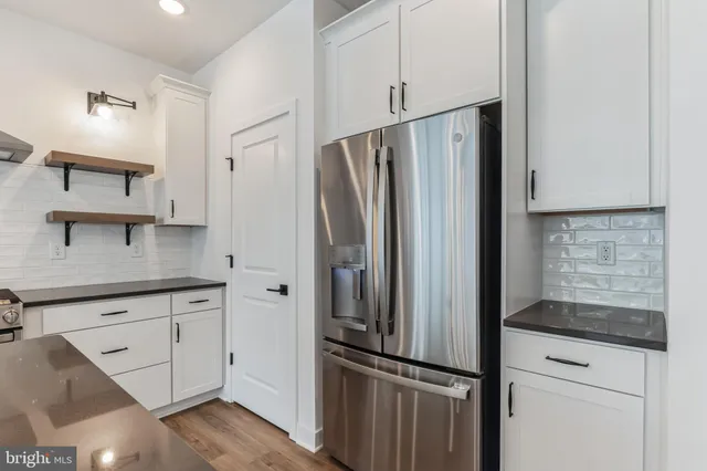 a kitchen with stainless steel appliances granite countertop a refrigerator and a stove top oven