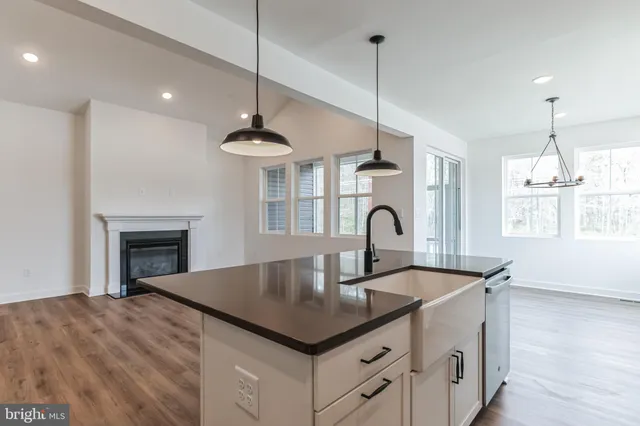 a kitchen with kitchen island a sink stainless steel appliances and a chandelier