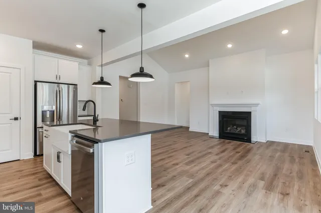 a kitchen with stainless steel appliances granite countertop a sink a stove and a refrigerator