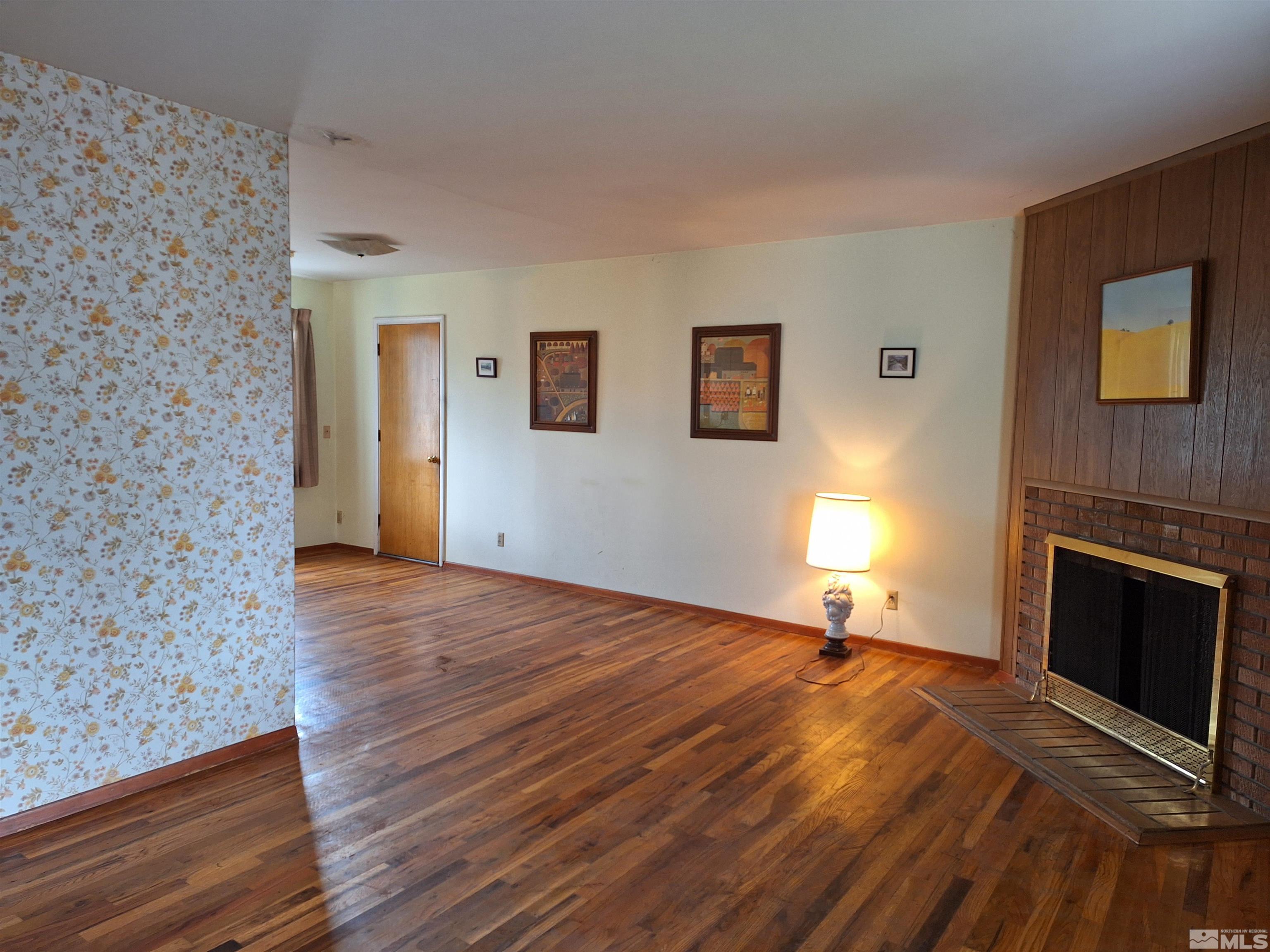 820 Ruby Avenue Reno, NV 89503 - Photo 5 of 30 a view of empty room with wooden floor and fireplace