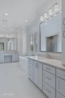 a bathroom with a granite countertop sink mirror and bathtub