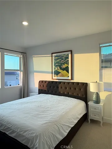 a bedroom with a large bed and windows