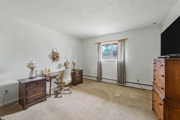 an empty room with furniture and a flat screen tv