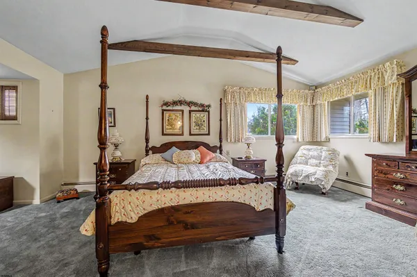 a bedroom with a bed dresser and a flat tv screen