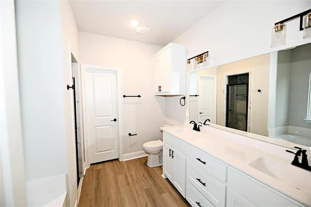 a bathroom with a double vanity sink toilet and shower