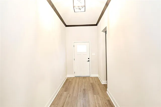 a kitchen with a sink a stove and white cabinets with wooden floor