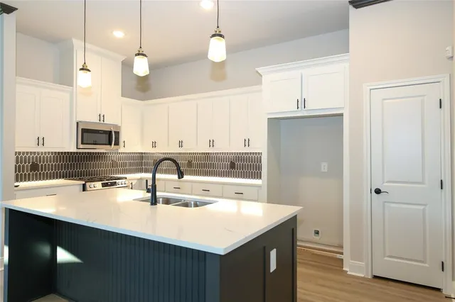a kitchen with a sink a stove a refrigerator and cabinets