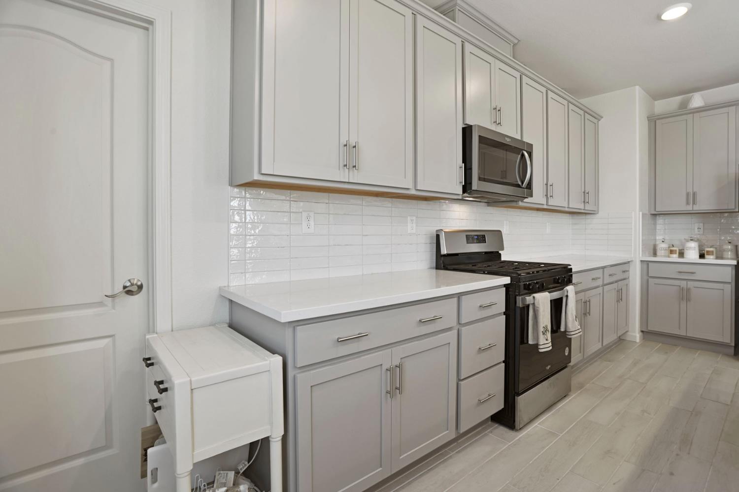 6949 Foraker Drive Stockton, CA 95219 - Photo 17 of 34 a kitchen with white cabinets and white appliances