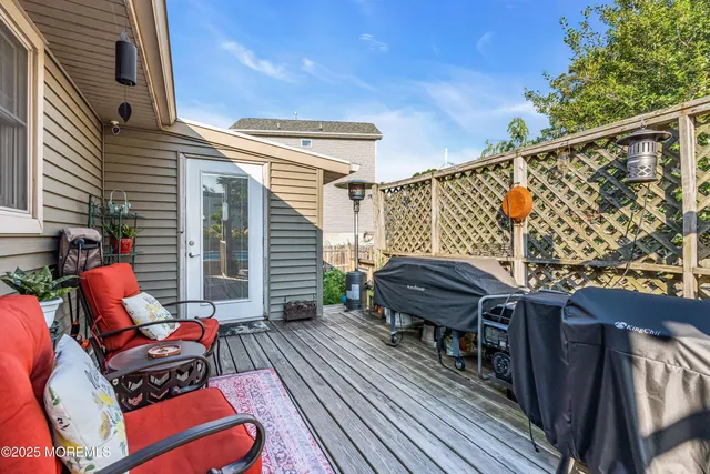 a balcony with wooden floor table and chairs
