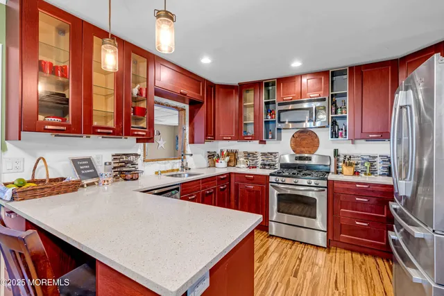 a kitchen with stainless steel appliances a stove a sink dishwasher and cabinets with wooden floor