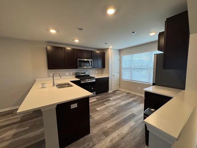 a kitchen with stainless steel appliances granite countertop a sink and stove top oven