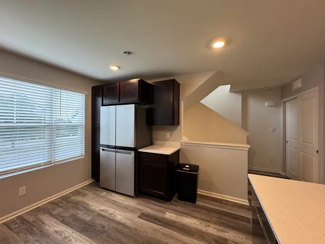 a view of a refrigerator in kitchen and an empty room
