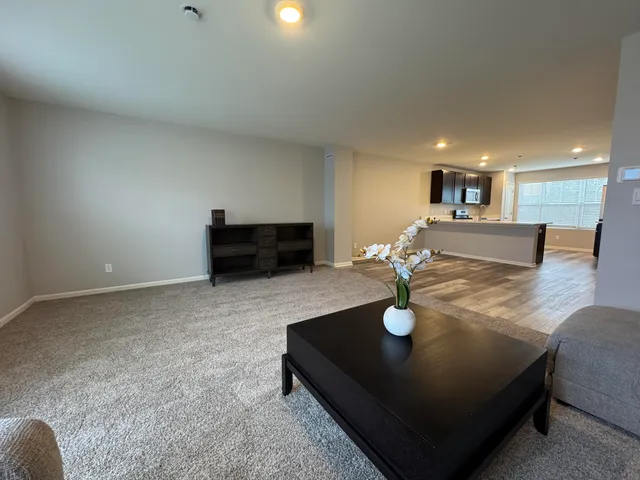 a view of kitchen with stainless steel appliances wooden floor and large window