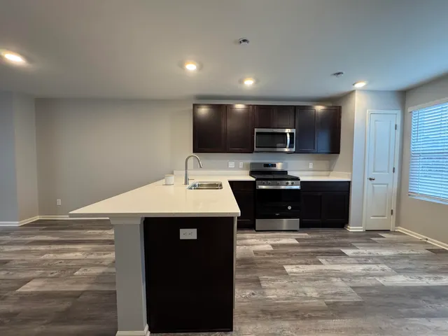 a kitchen with a sink a counter top space appliances and cabinets