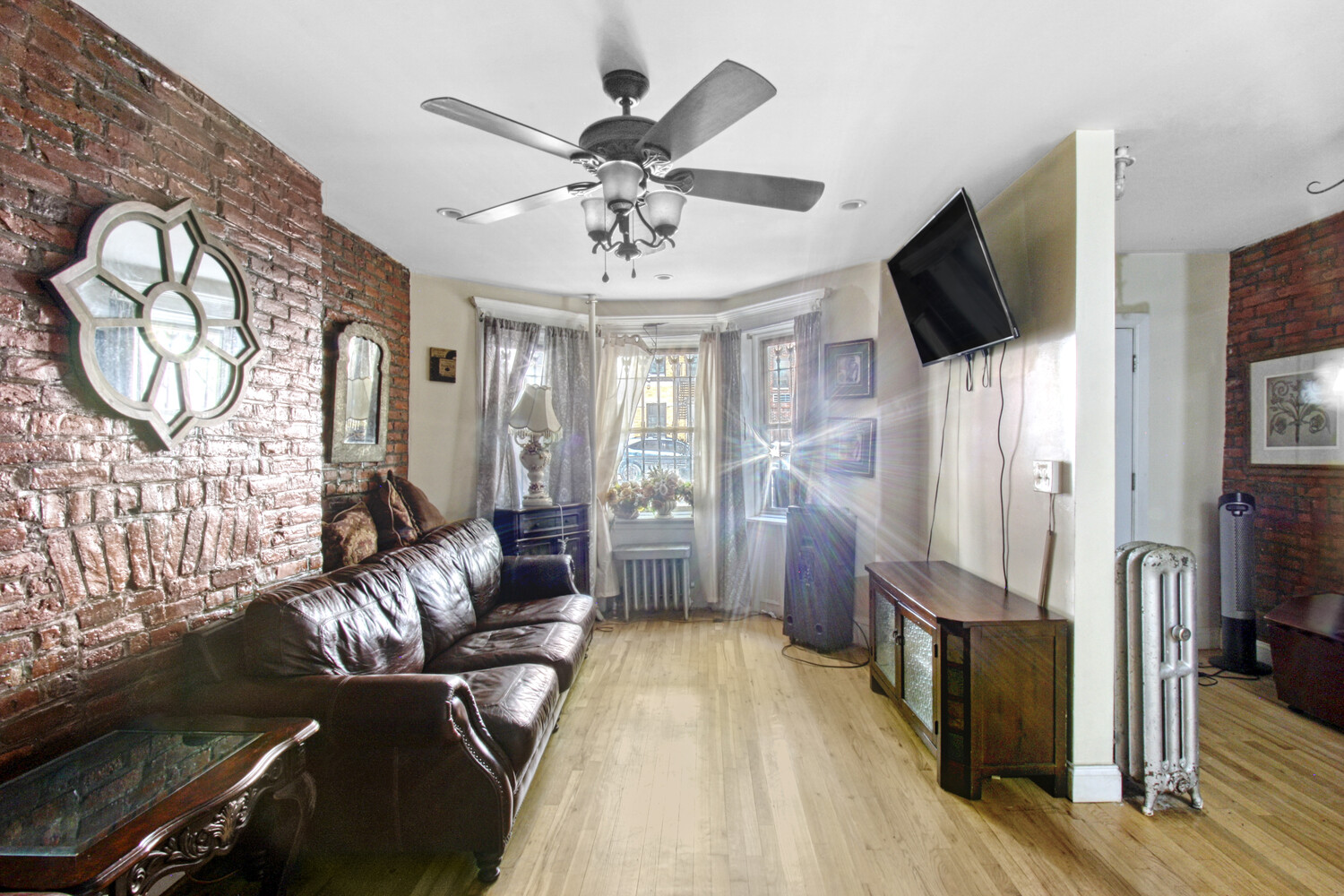 614 St Johns Place Brooklyn, NY 11238 - Photo 18 of 34 a living room with furniture a flat screen tv and a chandelier
