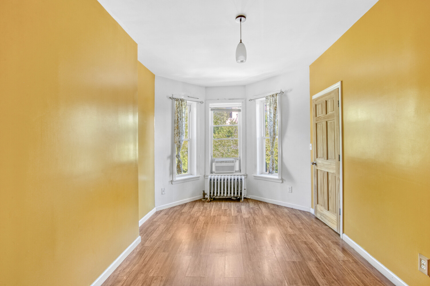 614 St Johns Place Brooklyn, NY 11238 - Photo 7 of 34 a view of empty room with wooden floor and fan