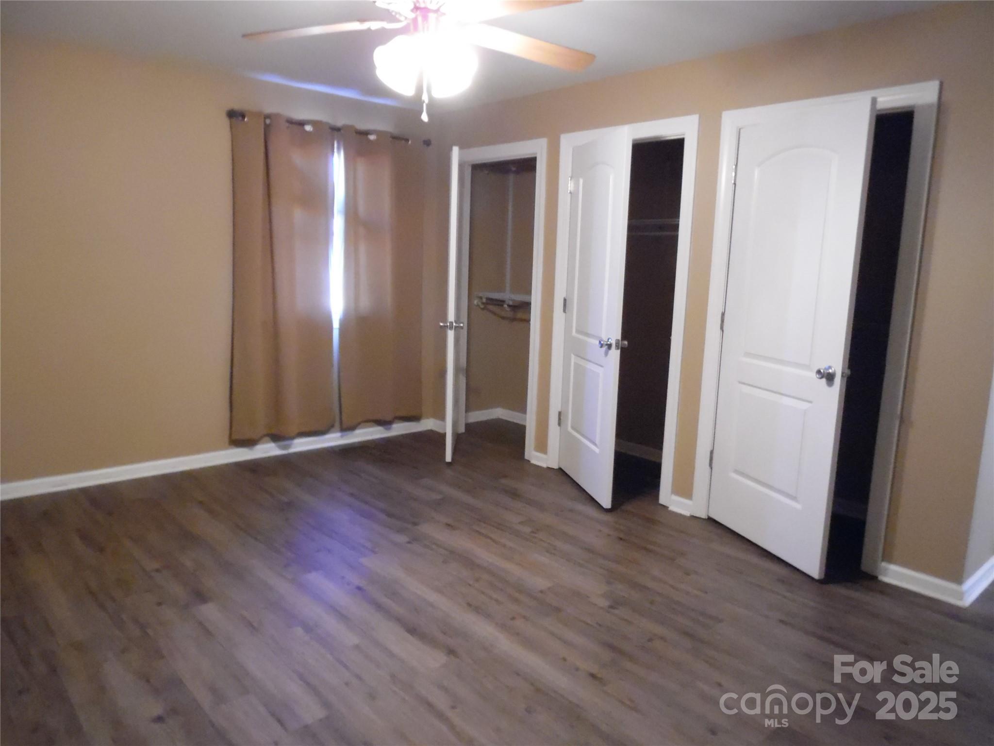 3857 Buffalo Shoals Road Maiden, NC 28650 - Photo 26 of 27 an empty room with wooden floor and a ceiling fan