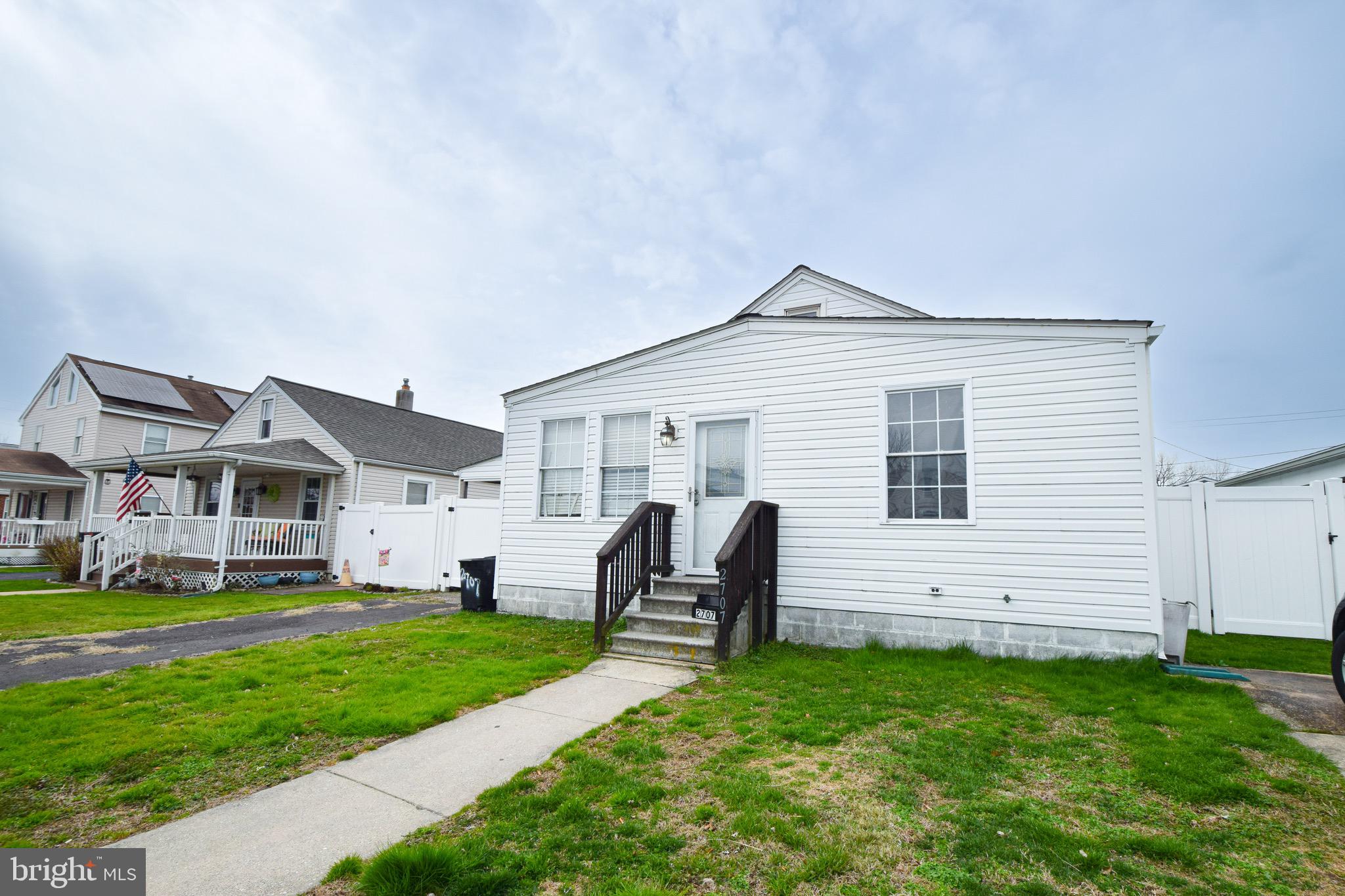 a front view of a house with a garden and chairs