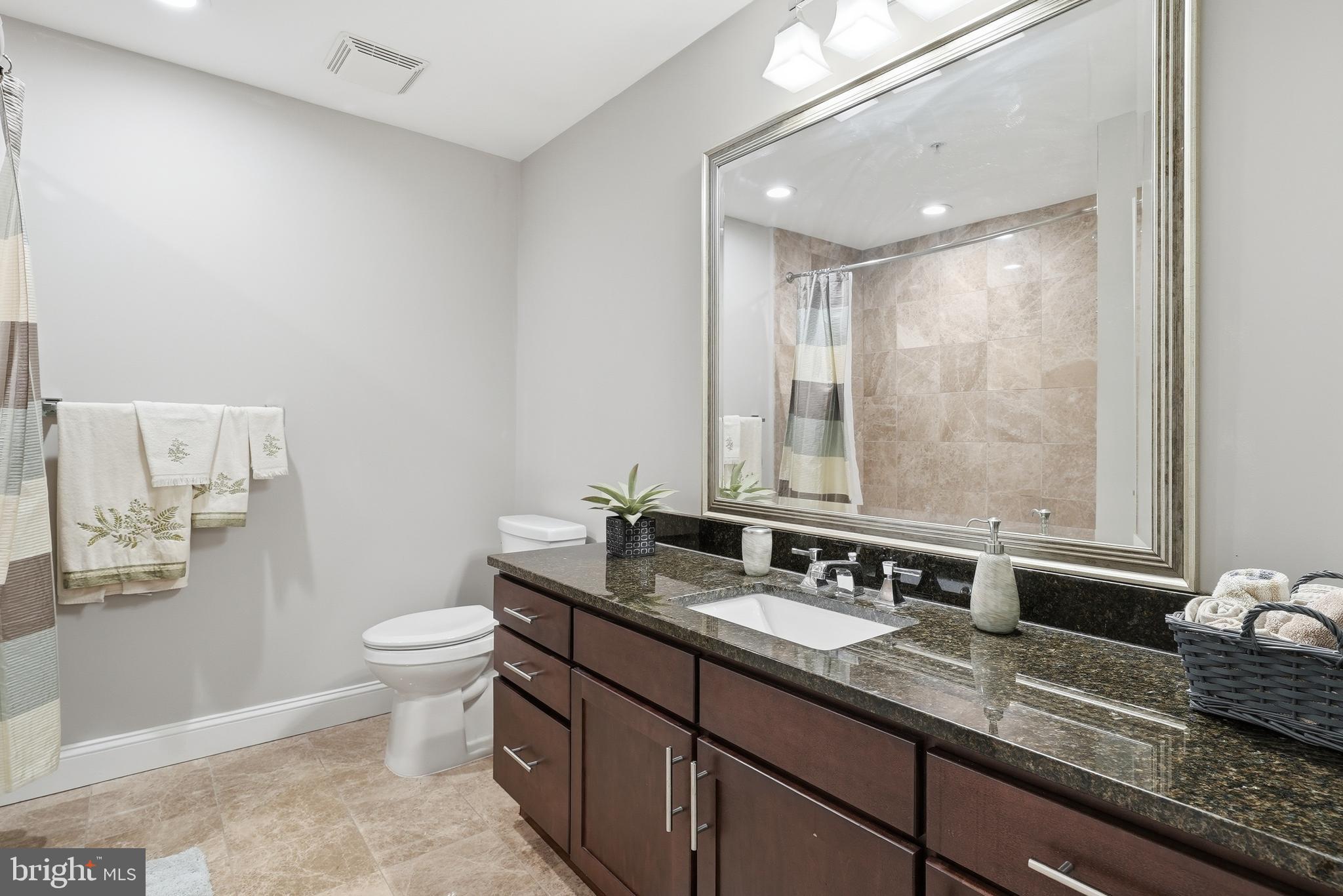 6301 Edsall Road, Unit 519 Alexandria, VA 22312 - Photo 8 of 33 a bathroom with a granite countertop sink a toilet and a mirror