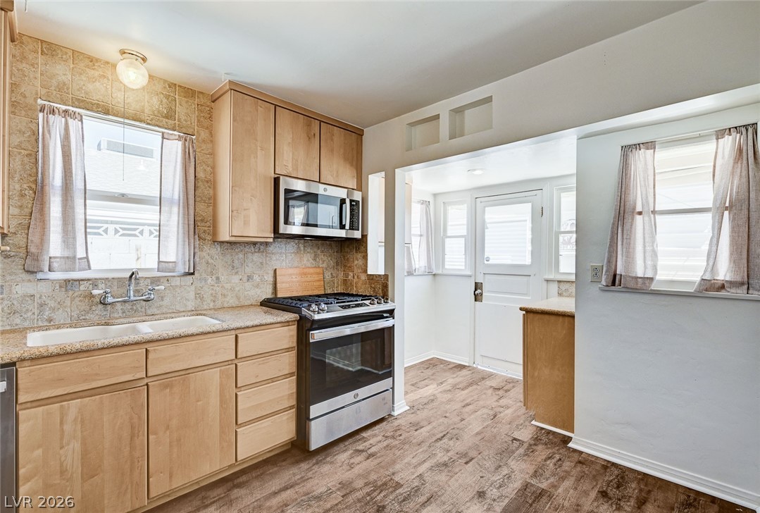 629 L Avenue Boulder City, NV 89005 - Photo 21 of 46 Kitchen with stainless steel appliances, light wood finish cabinets, light wood finished floors, light stone countertops, and backsplash