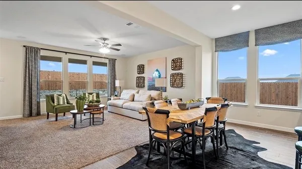 a kitchen with a dining table chairs and refrigerator