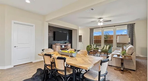 a dining room with furniture and a large window