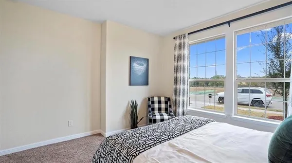 a bedroom with a bed and painting on the wall