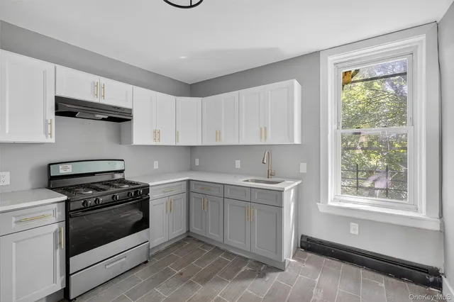 a kitchen with cabinets appliances and a window