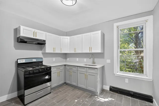 a kitchen with white cabinets and appliances