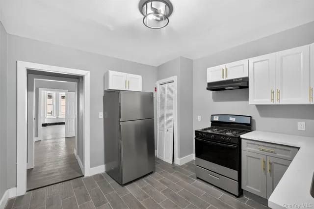 a kitchen with a refrigerator stove and white cabinets