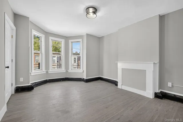an empty room with windows and fireplace