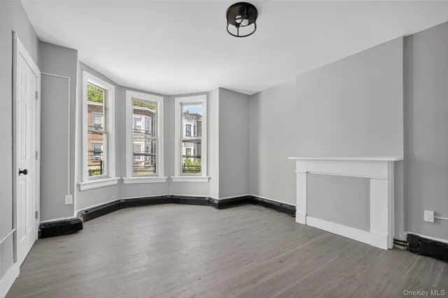 an empty room with a hardwood and a window