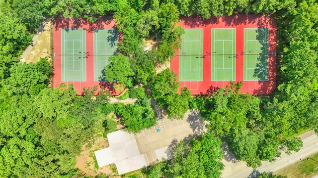 an aerial view of residential house with outdoor space and trees all around