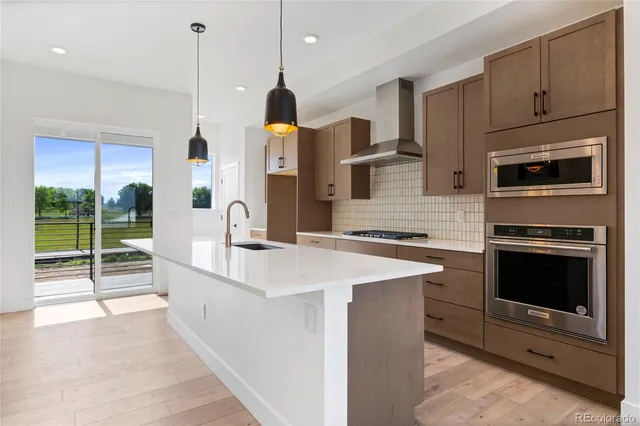 a kitchen with stainless steel appliances kitchen island granite countertop a sink and a microwave