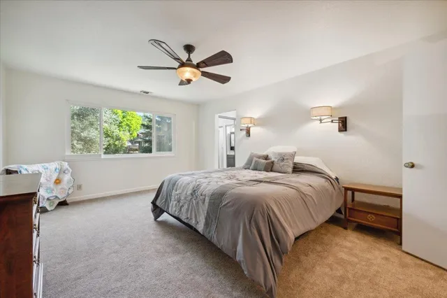 a spacious bedroom with a bed and a chandelier