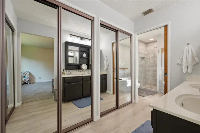 a en suite bathroom with a sink mirror and a bathtub