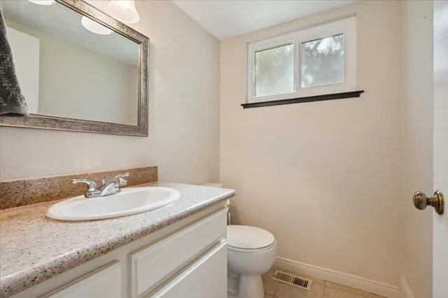 a view of a white house with a small yard and plants