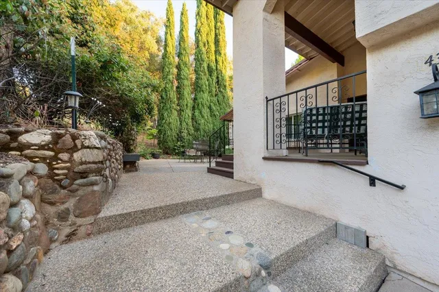 a yellow house with trees in front of it