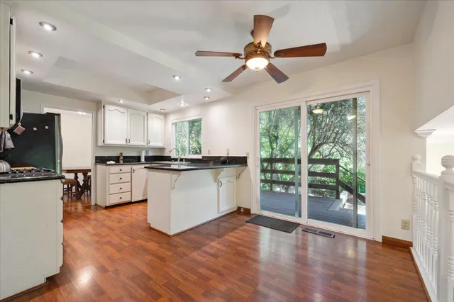 a kitchen with stainless steel appliances granite countertop a refrigerator a stove a sink and a large window