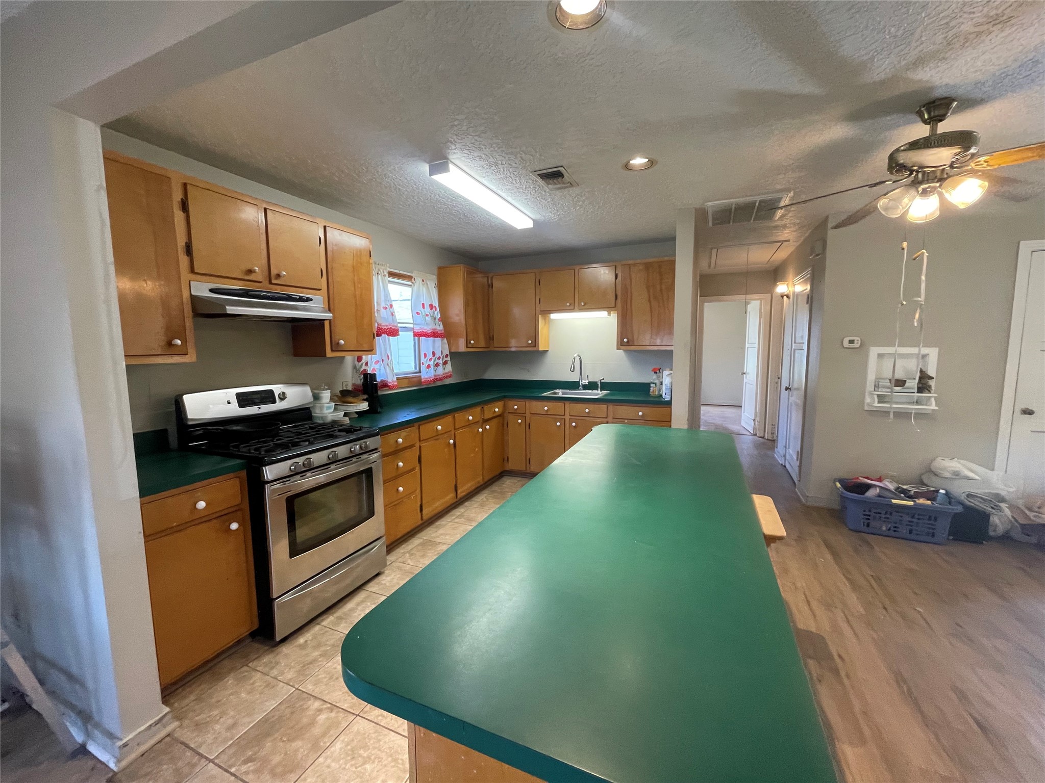 6642 Teluco Street Houston, TX 77055 - Photo 8 of 27 a kitchen with stainless steel appliances granite countertop a sink a stove top oven a chimney and a center island