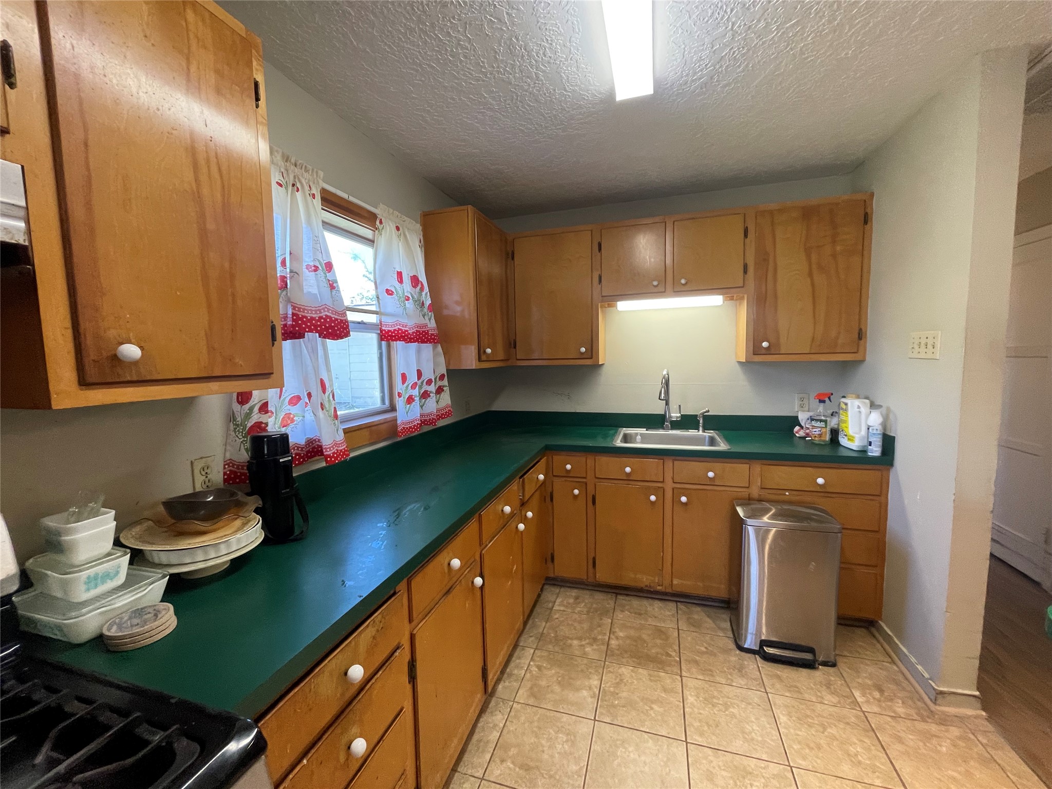 6642 Teluco Street Houston, TX 77055 - Photo 9 of 27 a kitchen with wooden cabinets and sink