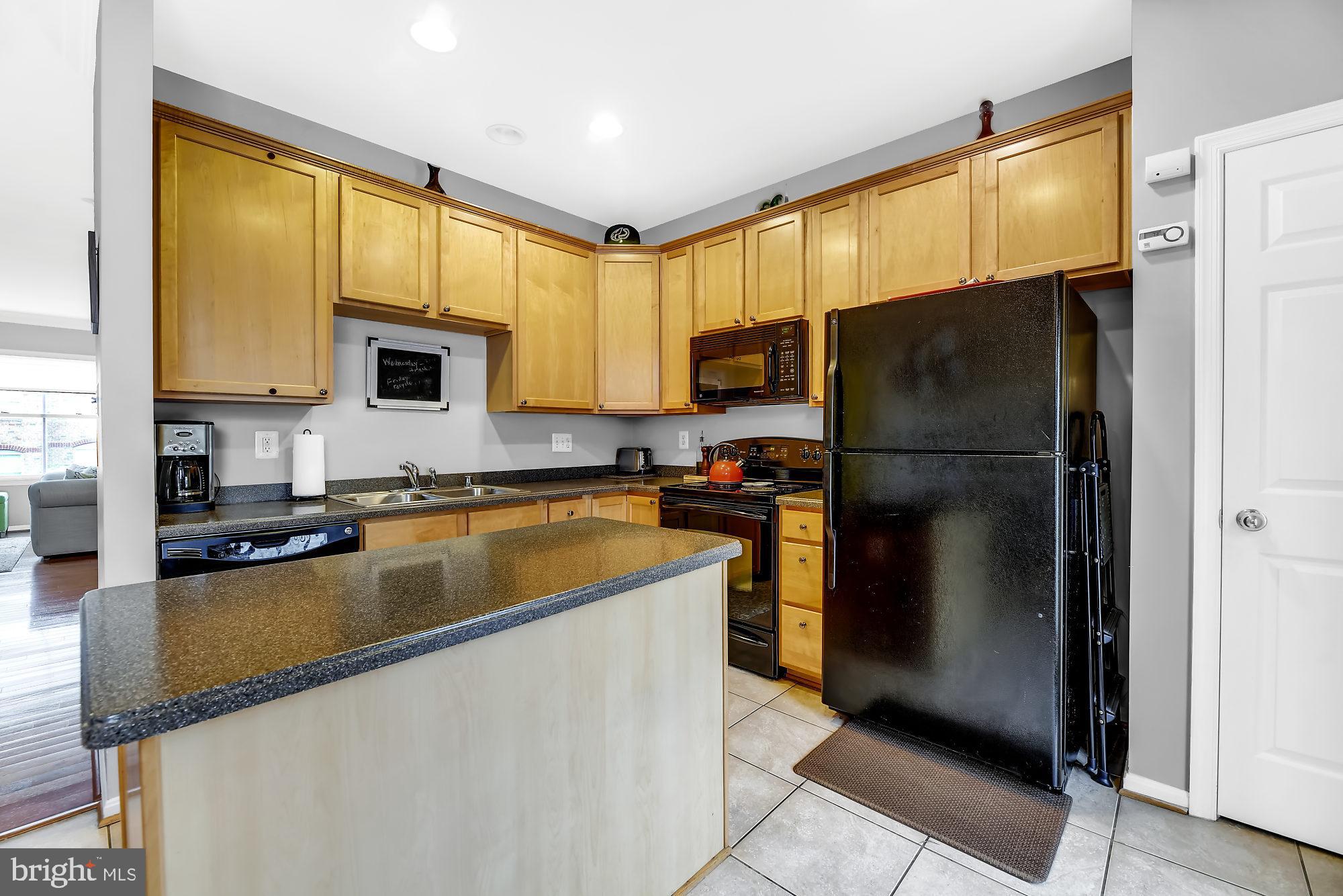 2090 Clipper Park Road Baltimore, MD 21211 - Photo 8 of 75 a kitchen with a refrigerator a microwave a sink and cabinets