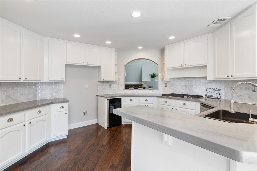 31895 Dane Court Temecula, CA 92591 - Photo 12 of 48 a kitchen with stainless steel appliances granite countertop a sink dishwasher a refrigerator and white cabinets with wooden floor