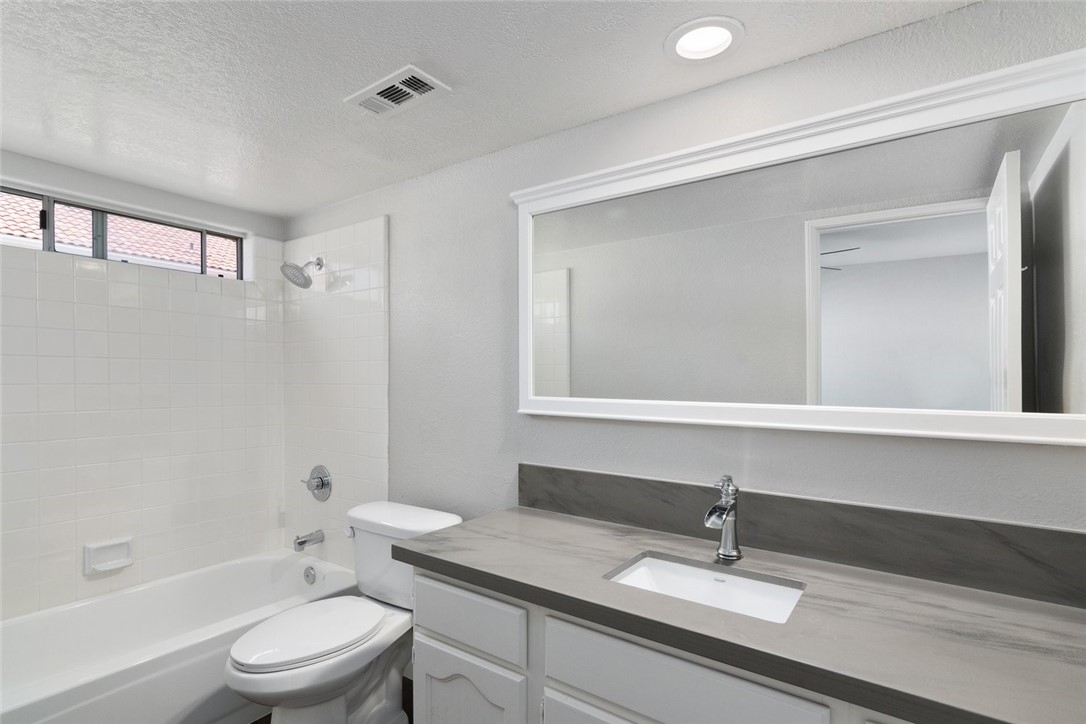 31895 Dane Court Temecula, CA 92591 - Photo 20 of 48 a bathroom with a granite countertop sink a toilet a mirror and shower