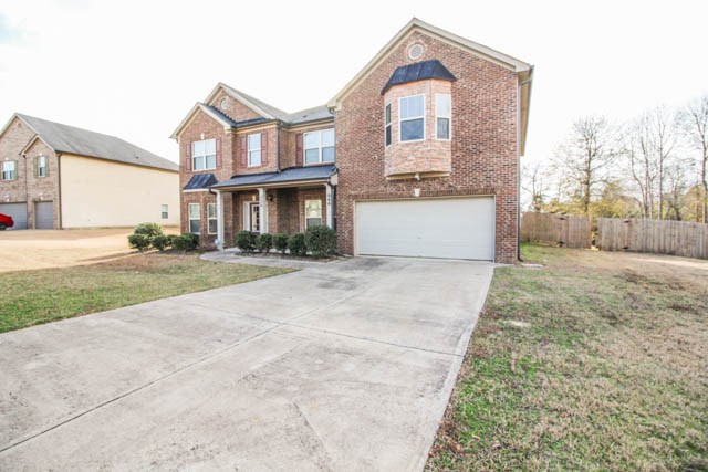 22 Riverside Drive Fort Mitchell, AL 36856 - Photo 2 of 28 a front view of a house with a yard and garage